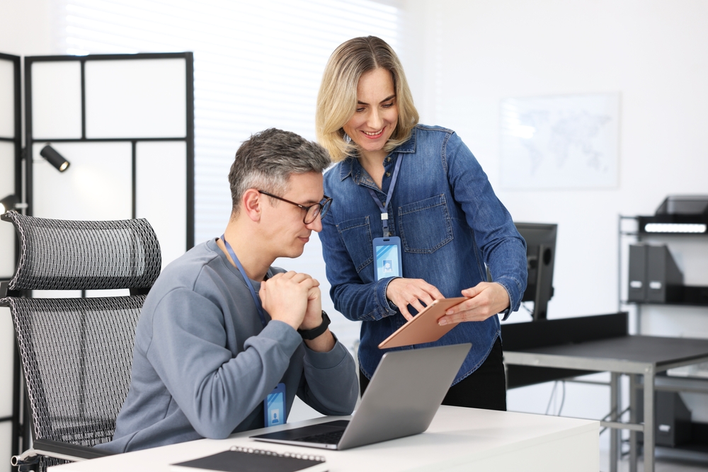 Engineers reviewing digital models on computer screens while comparing digital twin vs simulation in an industrial technology environment.