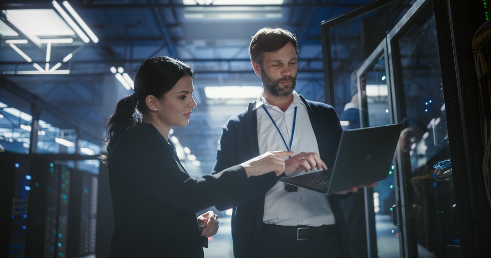 Professionals collaborating at computer workstations to evaluate digital twin vs simulation for manufacturing and operational planning.
