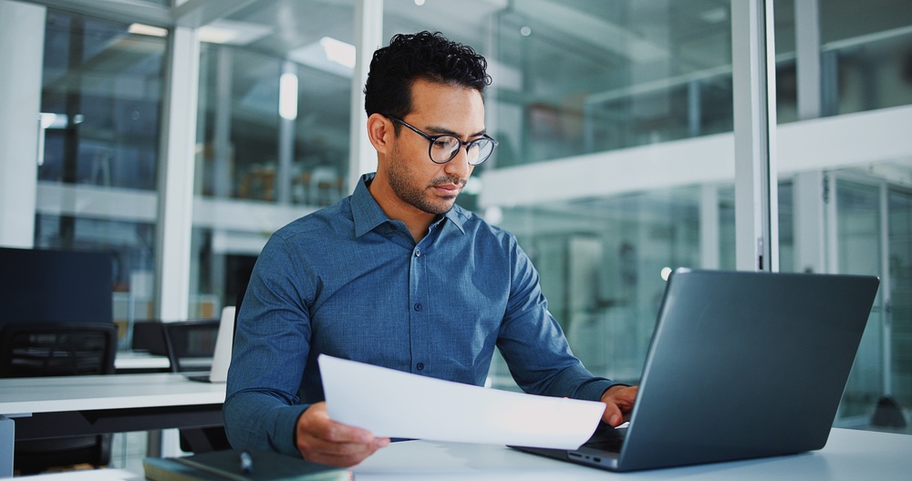 Professional reviewing data on a computer as part of a simulation modeling analysis for business decision making.