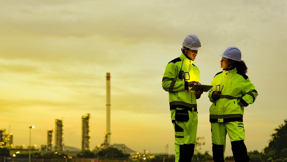 Process plant engineer analyzing scenario planning data on a tablet screen
